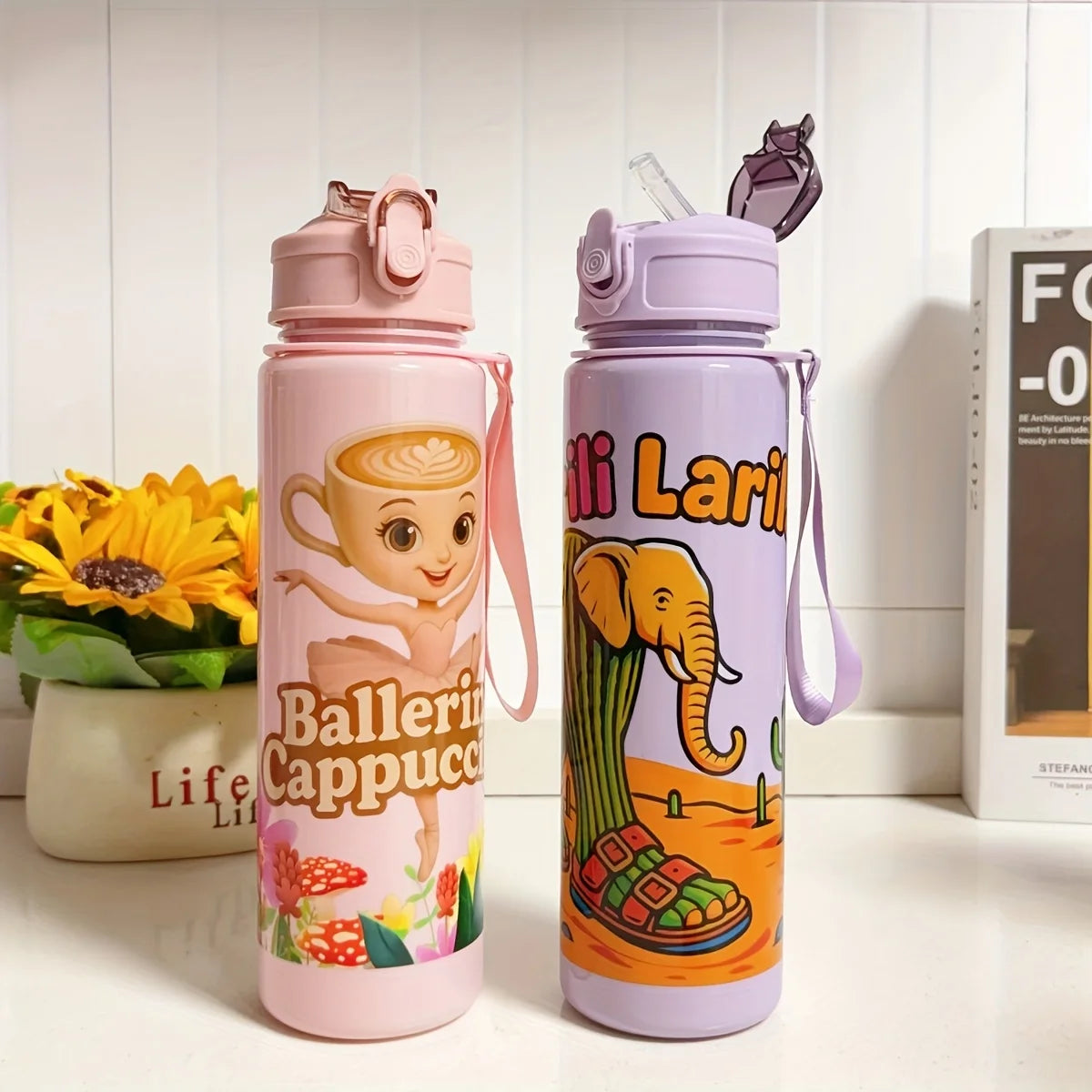 A pink and purple insulated sports water bottle with an elephant design and a lid, standing on a white surface.