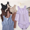 A collection of various colored, fitted bodysuits and tops displayed on a white surface.