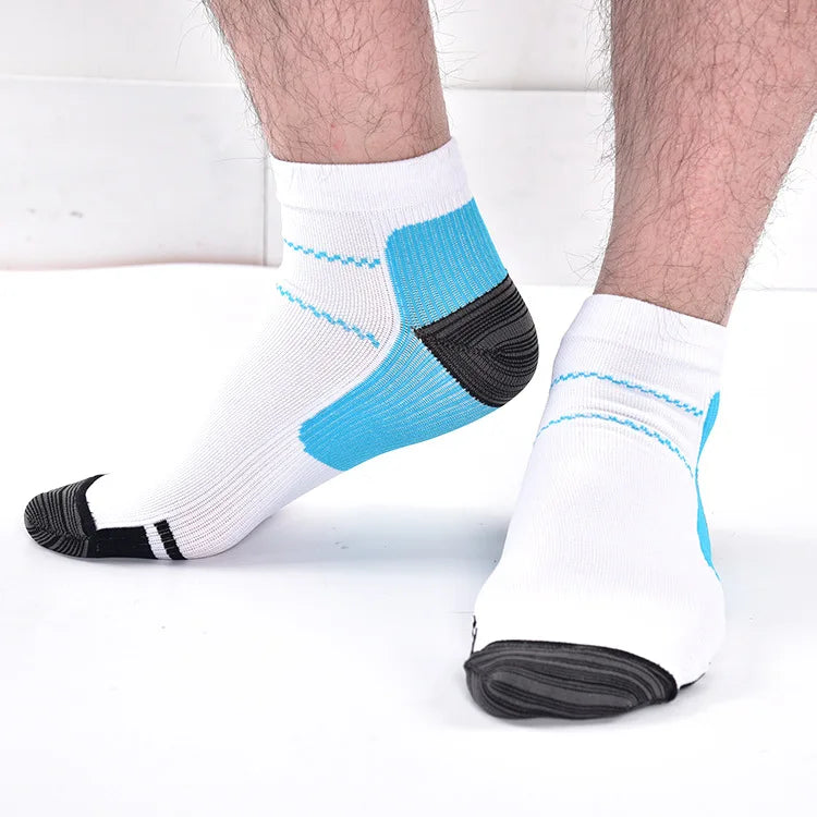 White compression socks with blue and black arch support detailing on a person's foot.