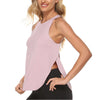 A woman wearing a light pink quick-dry yoga and gym tank top and black athletic pants.
