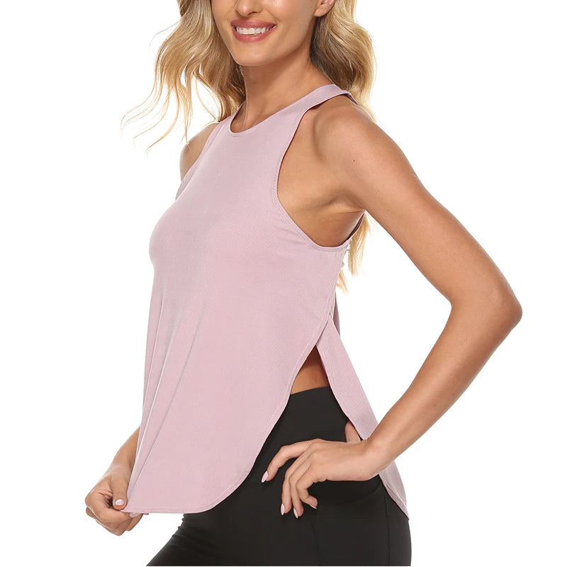 A woman wearing a light pink quick-dry yoga and gym tank top and black athletic pants.