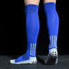 A pair of royal blue long football training socks with a white patterned sole are displayed against a black background.