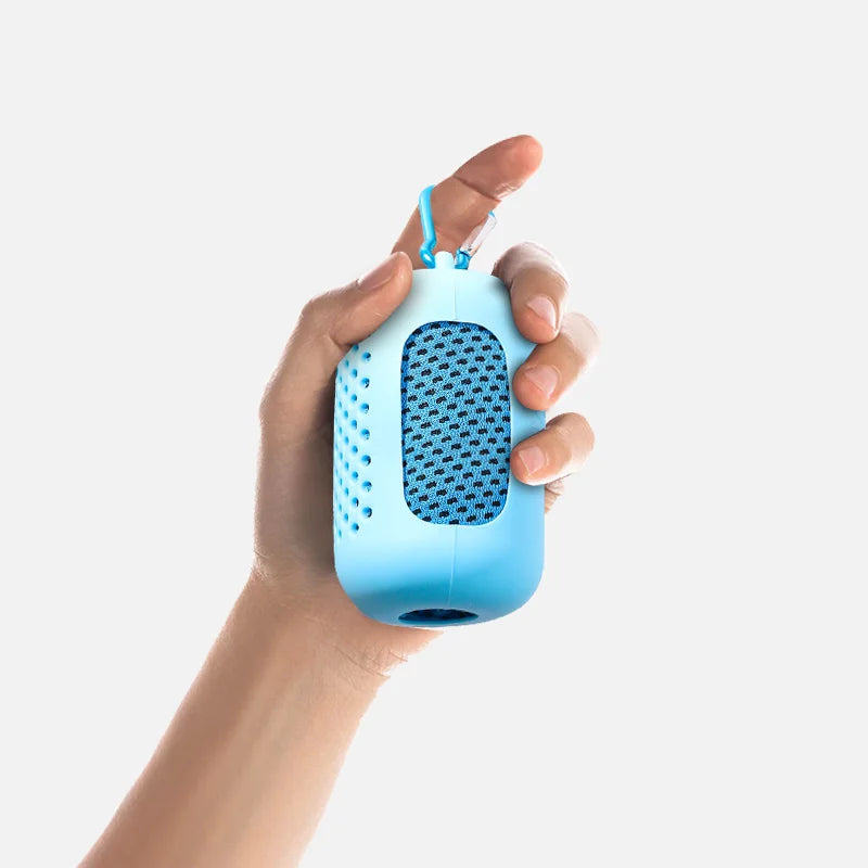 A hand is holding a light blue cooling towel with a mesh texture and a blue clip.