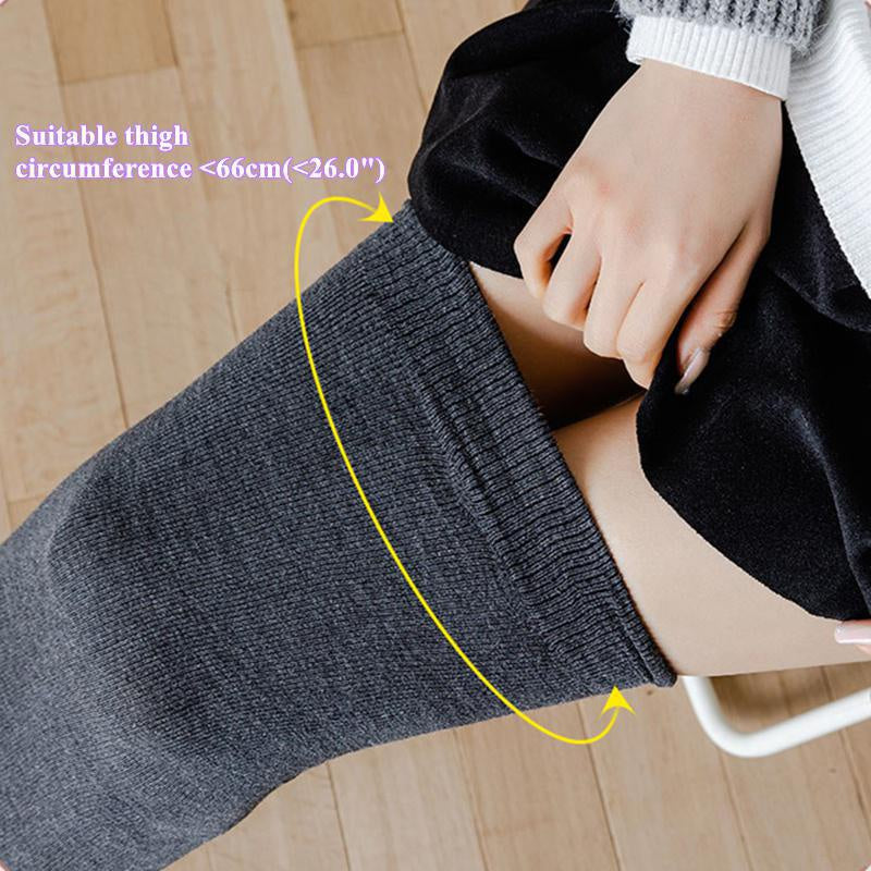 A close-up of gray thigh high leg warmers being worn on a leg, showing the fit around the thigh.