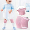 Baby in white clothing and pink knee pads for crawling safety.