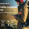 A man is using the Etenwolf Air 3 portable outdoor pump, a tiny electric pump, in an outdoor setting.