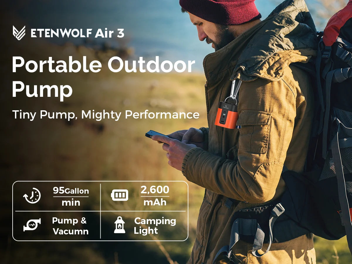 A man is using the Etenwolf Air 3 portable outdoor pump, a tiny electric pump, in an outdoor setting.