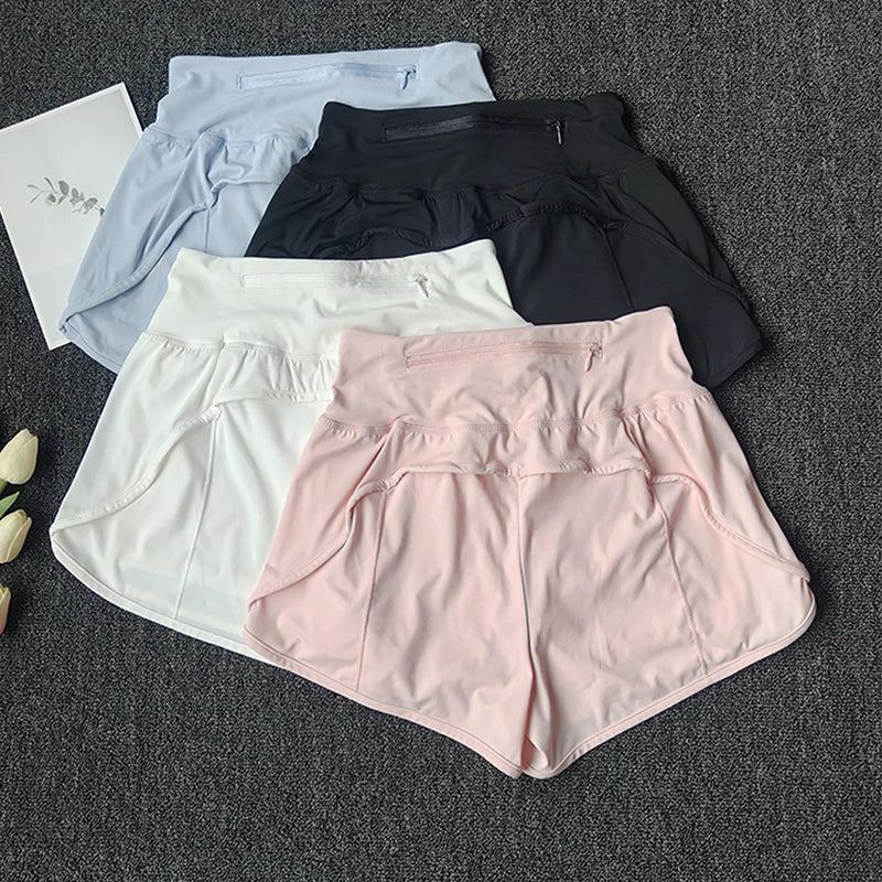 A collection of women's high-waist yoga and fitness shorts in various colors including light blue, black, and pink, laid out 