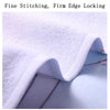 Close-up of a white microfiber beach towel showing fine stitching and firm edge locking.