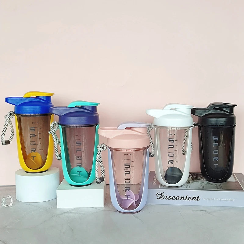 A collection of colorful 600ml blender shaker bottles in various shades including blue, green, yellow, and black, displayed o