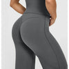 A woman wearing high waisted wide leg yoga pants in a solid gray color.