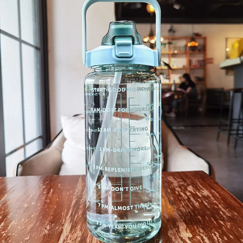Una botella de agua de viaje aislada y transparente con tapa y pajita azules, sobre una mesa de madera.