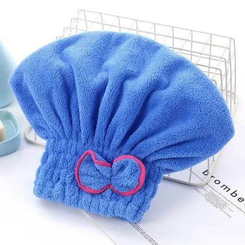 A bright blue, fluffy hair drying towel cap is displayed on a wire rack.