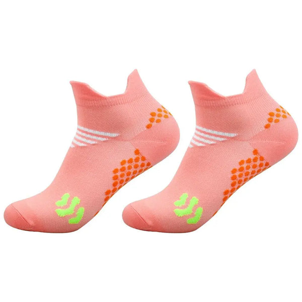 A pair of coral pink cycling and running socks with white stripes and orange dots.