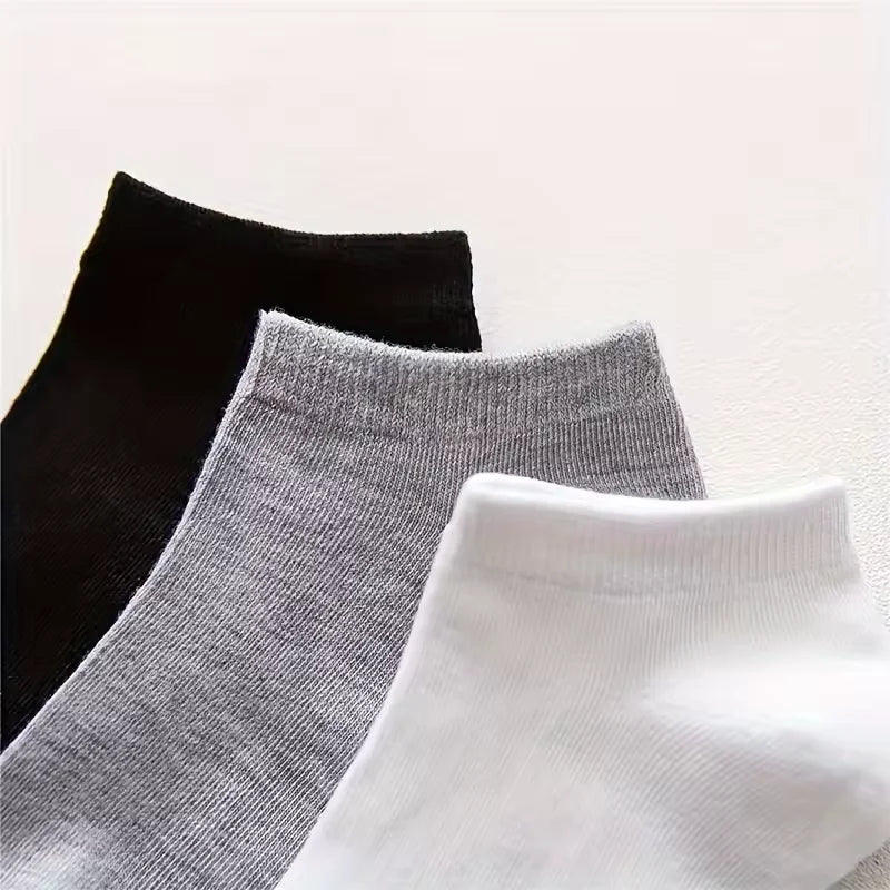 A stack of black, gray, and white ankle socks displayed against a white background.