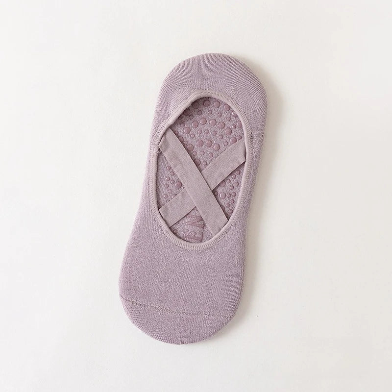 A pair of mauve non-slip yoga and gym socks with a silicone grip on the sole.