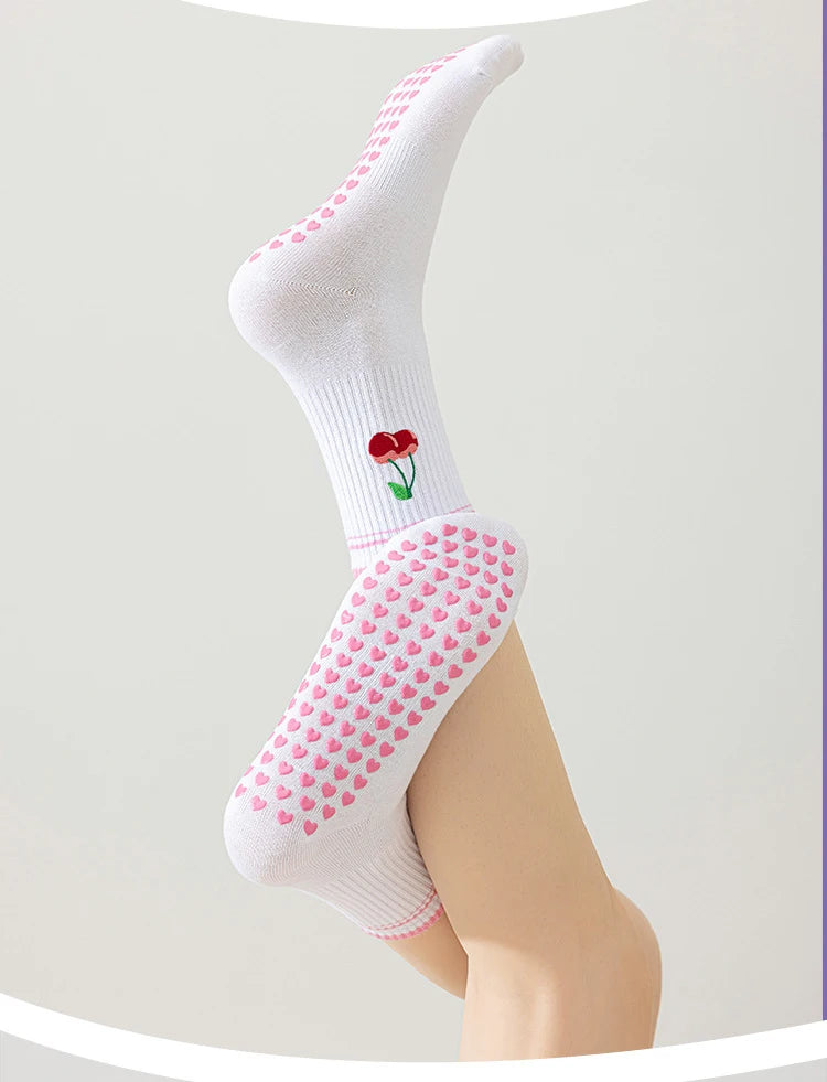 Chaussettes de yoga blanches avec des cœurs roses brodés et un petit détail de fleur rouge