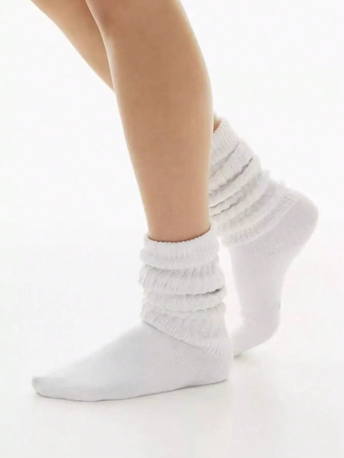 White slouch knit scrunch socks worn on a leg.