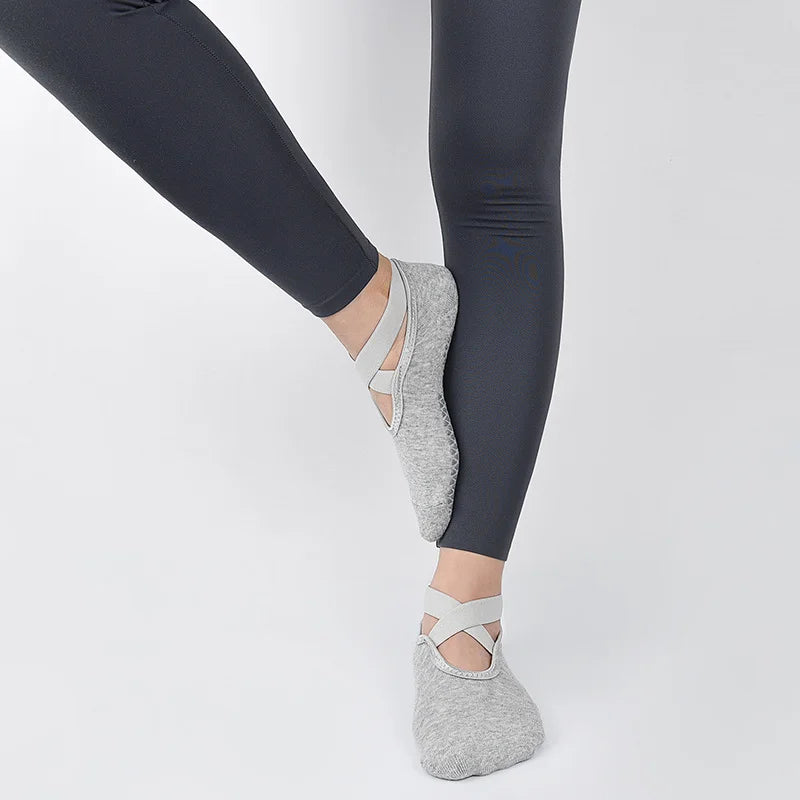 Calcetines antideslizantes grises puestos en un pie, combinados con leggings oscuros.