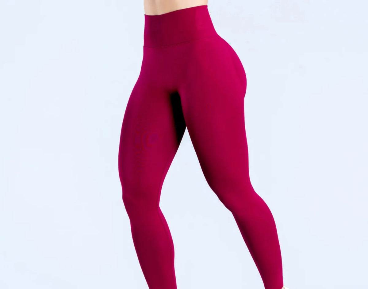 Primer plano de un legging de yoga sin costuras de talle alto en color magenta intenso.