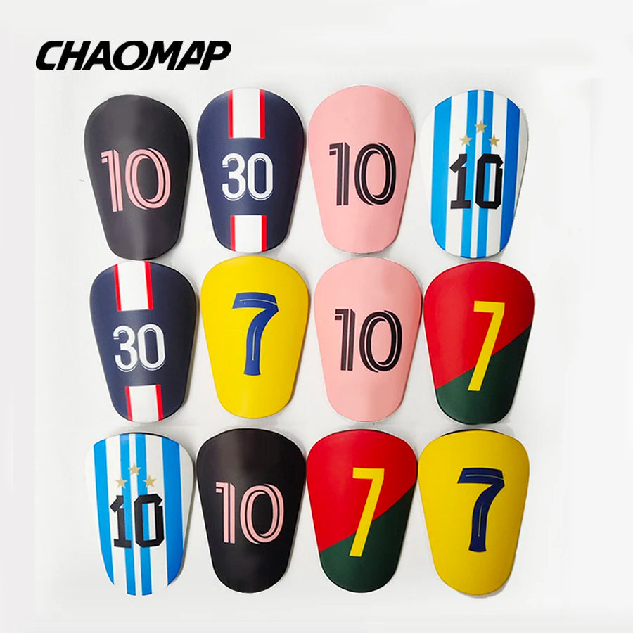A collection of ten mini football shin guards in various colors and numbers, including black, pink, yellow, and blue.