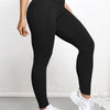 A woman wearing black high-waisted sports leggings and white sneakers.