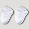 Una pila de calcetines de algodón transpirables unisex blancos de tobillo, dispuestos sobre una superficie clara.