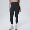 A model wearing black high-waisted quick-drying yoga and fitness leggings and white athletic shoes.