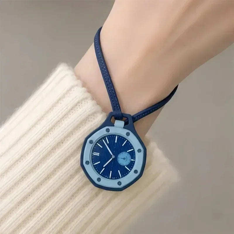 A blue octagonal quartz pocket watch is worn on a wrist, visible against a cream-colored knitted sleeve.