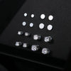A collection of magnetic cubic zirconia stud earrings arranged on a dark surface.