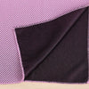 A close-up of a purple microfiber cooling towel folded next to a black one on a wooden surface.