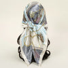 Elegant satin square scarf featuring gold chain details and floral embroidery for hijab and hair