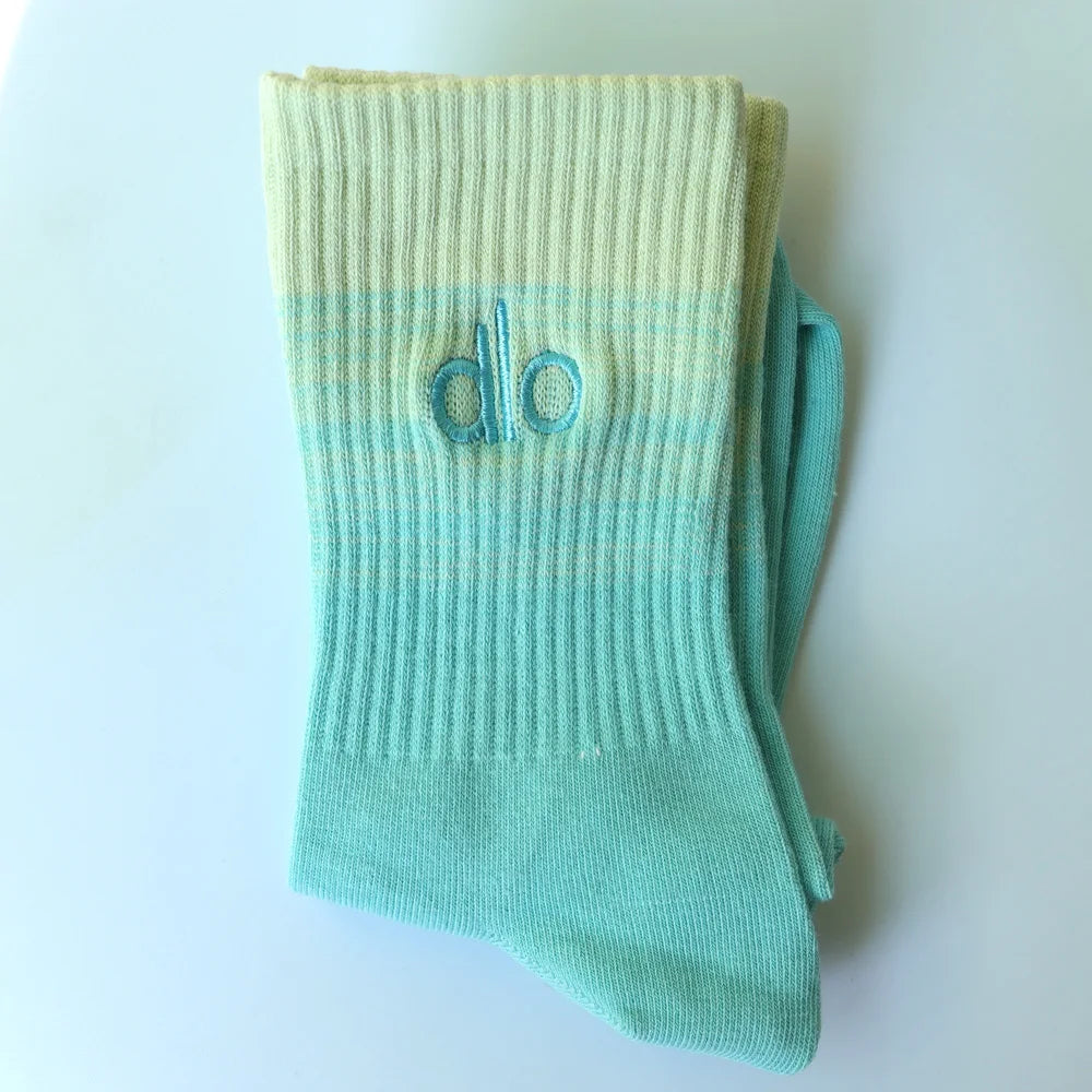 Light mint green knitted socks with a light blue stripe and the word do embroidered on the toe area