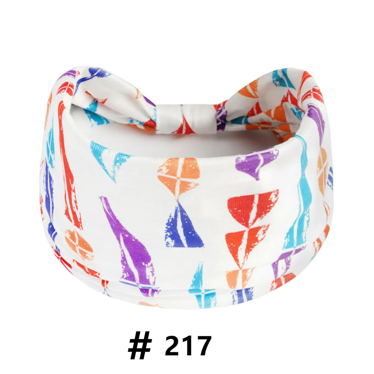 A white cotton turban headband with a colorful abstract print featuring orange, purple, and blue stripes.