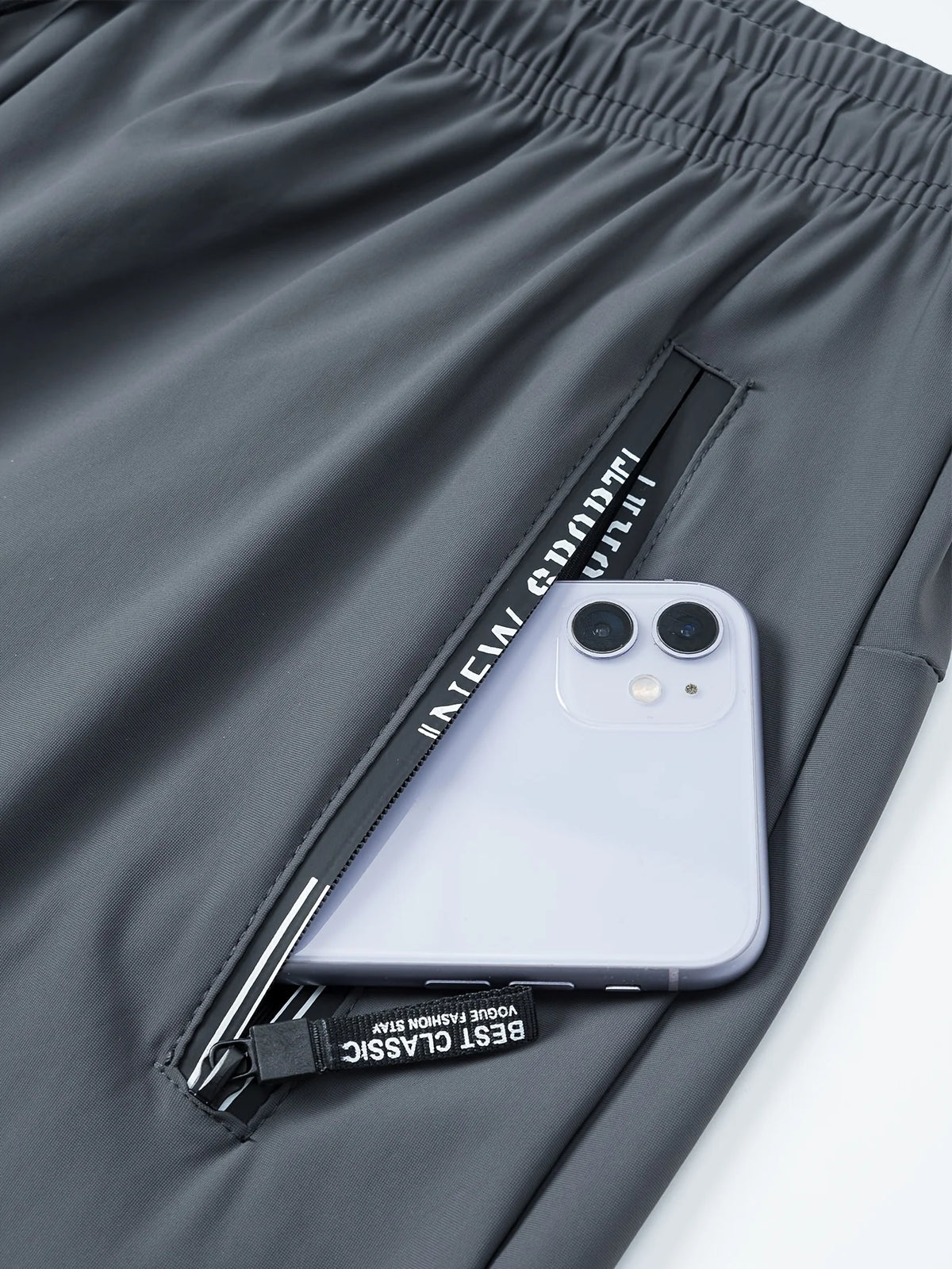 Gray jogger pants with a zippered pocket displaying an iPhone.