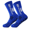 A pair of royal blue anti-slip performance sports socks with white text and black dots.