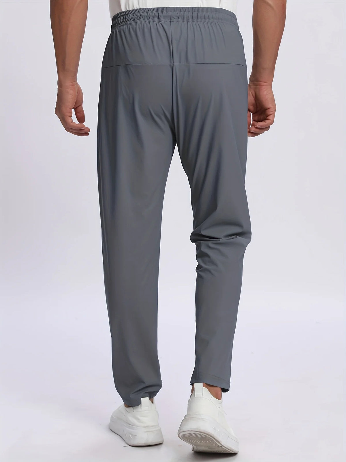 A pair of charcoal gray breathable men's casual jogger pants being worn by a person.