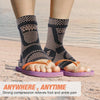 A person wearing black copper infused ankle compression socks on a sandy beach.