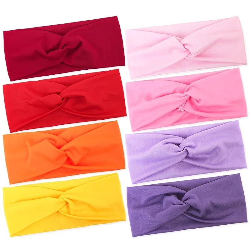 A collection of nine knotted elastic sports headbands in various shades including maroon, red, pink, orange, and purple.