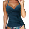 A model wearing a dark teal ruched, V-neck swimsuit top and matching high-waisted bottoms.