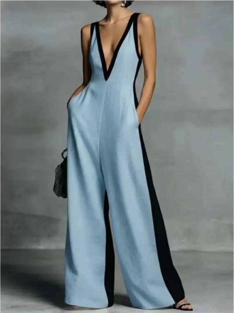Un mannequin porte une combinaison à col en V bleu clair, à blocs de couleurs et avec des détails noirs et des poches.