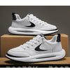 A pair of white Nike running shoes with black accents resting on a cardboard box.