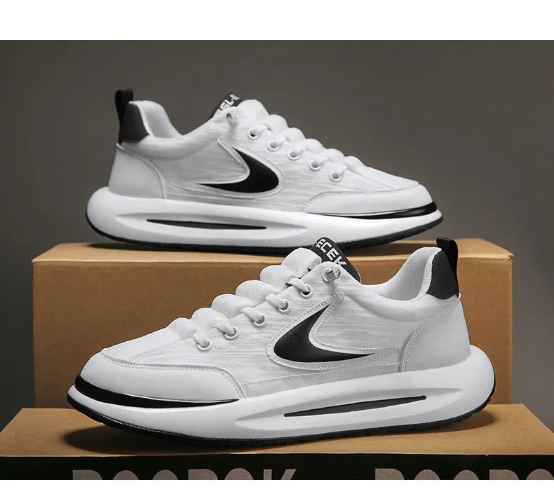 A pair of white Nike running shoes with black accents resting on a cardboard box.