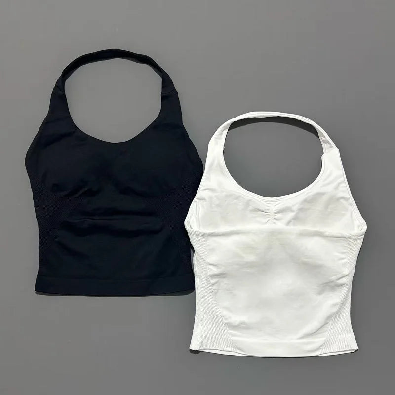 A black seamless performance yoga and gym tank top and a white seamless version displayed side by side.