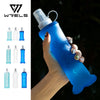 A hand holds a blue collapsible silicone water flask against a dark background.