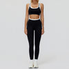 Eine Frau trägt ein schwarz-weißes Yoga- und Gym-Trainingsanzug-Set mit Crop-Top und passenden Leggings.