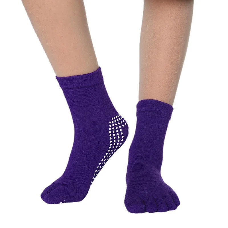 Purple yoga socks with a dotted pattern worn on a person's foot and ankle.