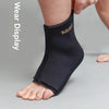 A person is wearing a black knee sleeve for hot and cold therapy on their lower leg.
