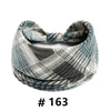 A folded patterned grey and white fabric turban headband for workout or yoga.