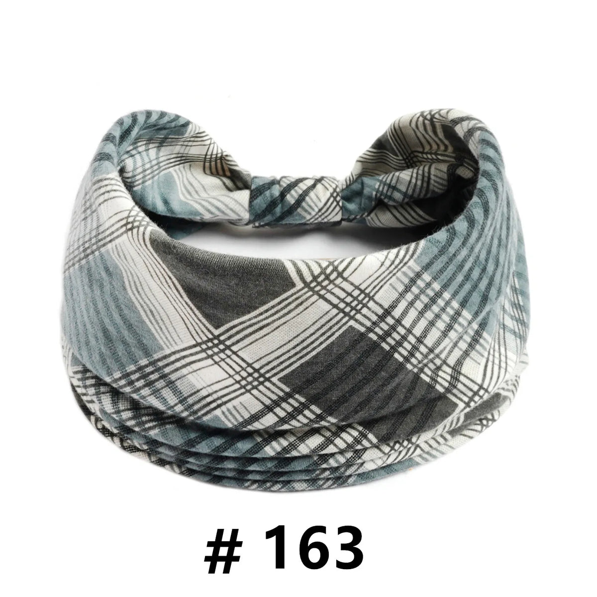 A folded patterned grey and white fabric turban headband for workout or yoga.
